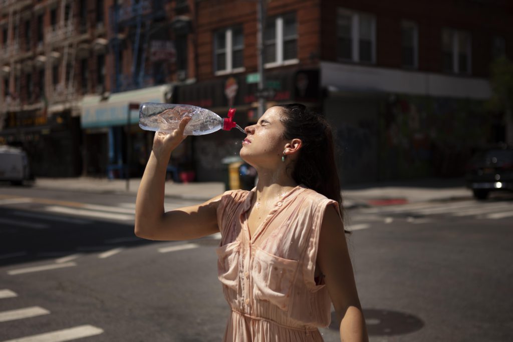 mujer-joven-tolerando-ola-calor-bebida-fria